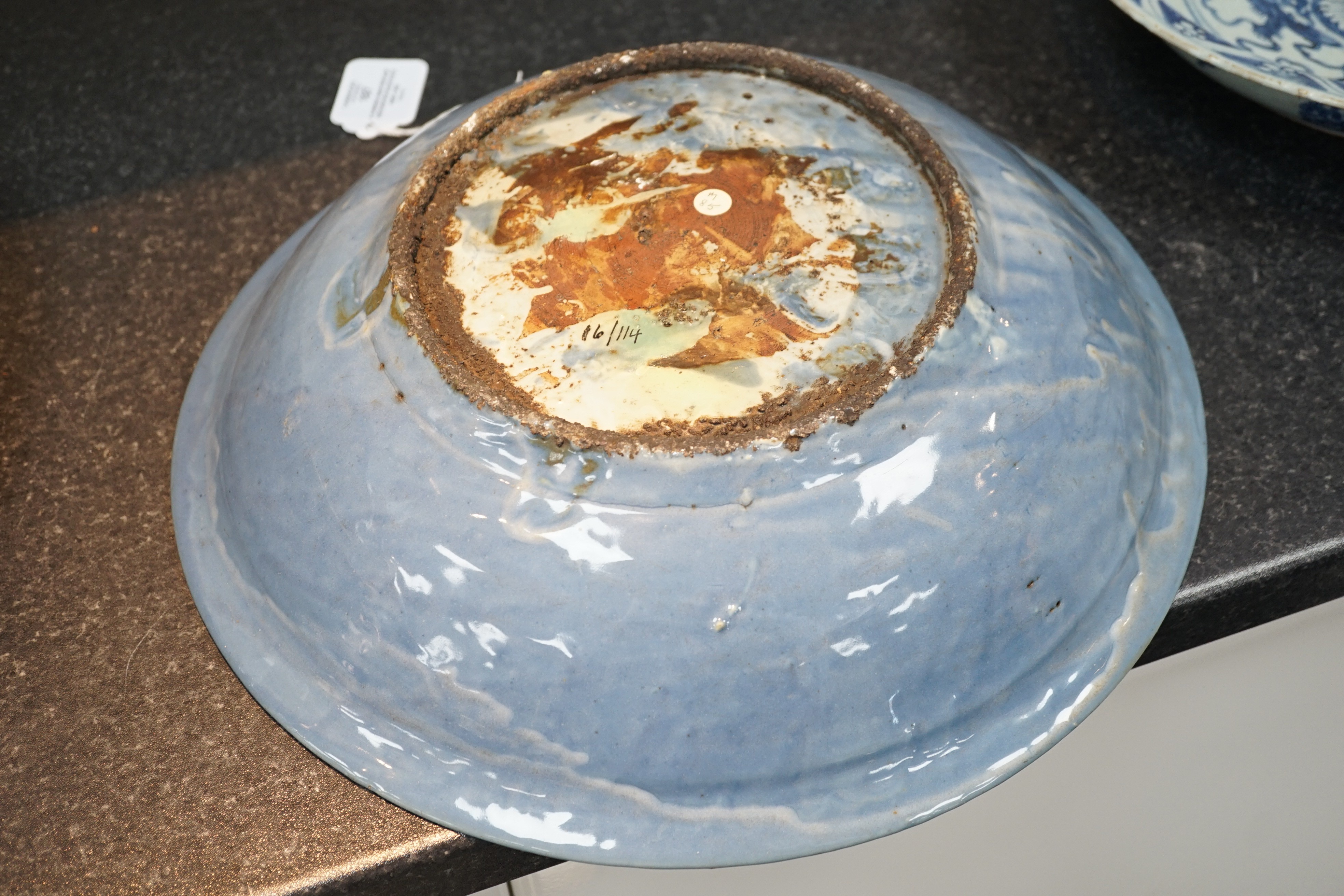 A Chinese Swatow slip-decorated blue glazed deep dish, Zhangzhou kilns, early 17th century, 38cm wide, crack to base